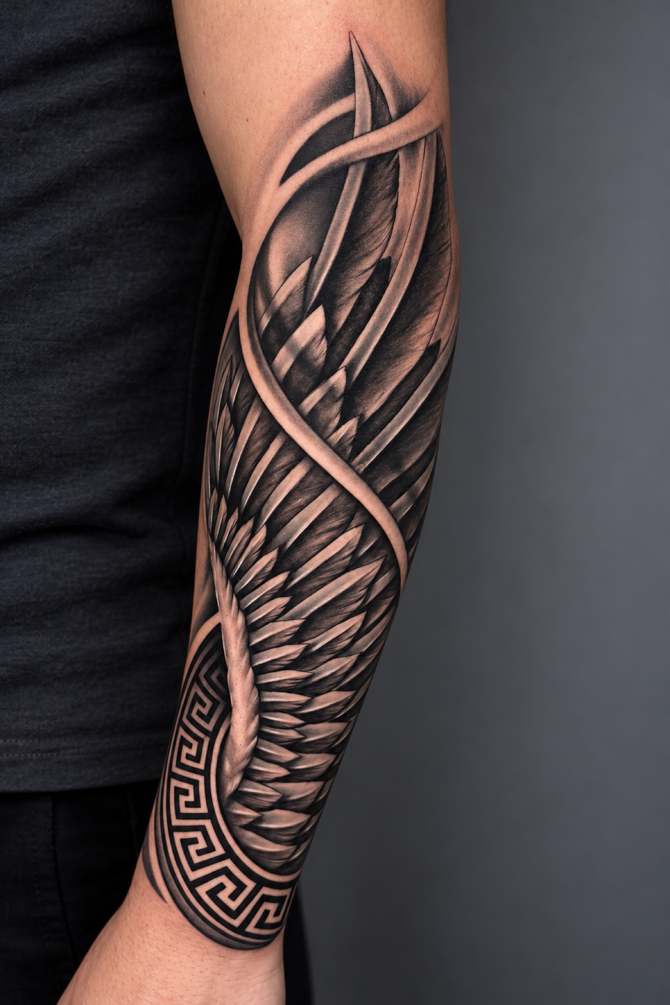 Black and grey feathered wing tattoo by Reynier Oliva