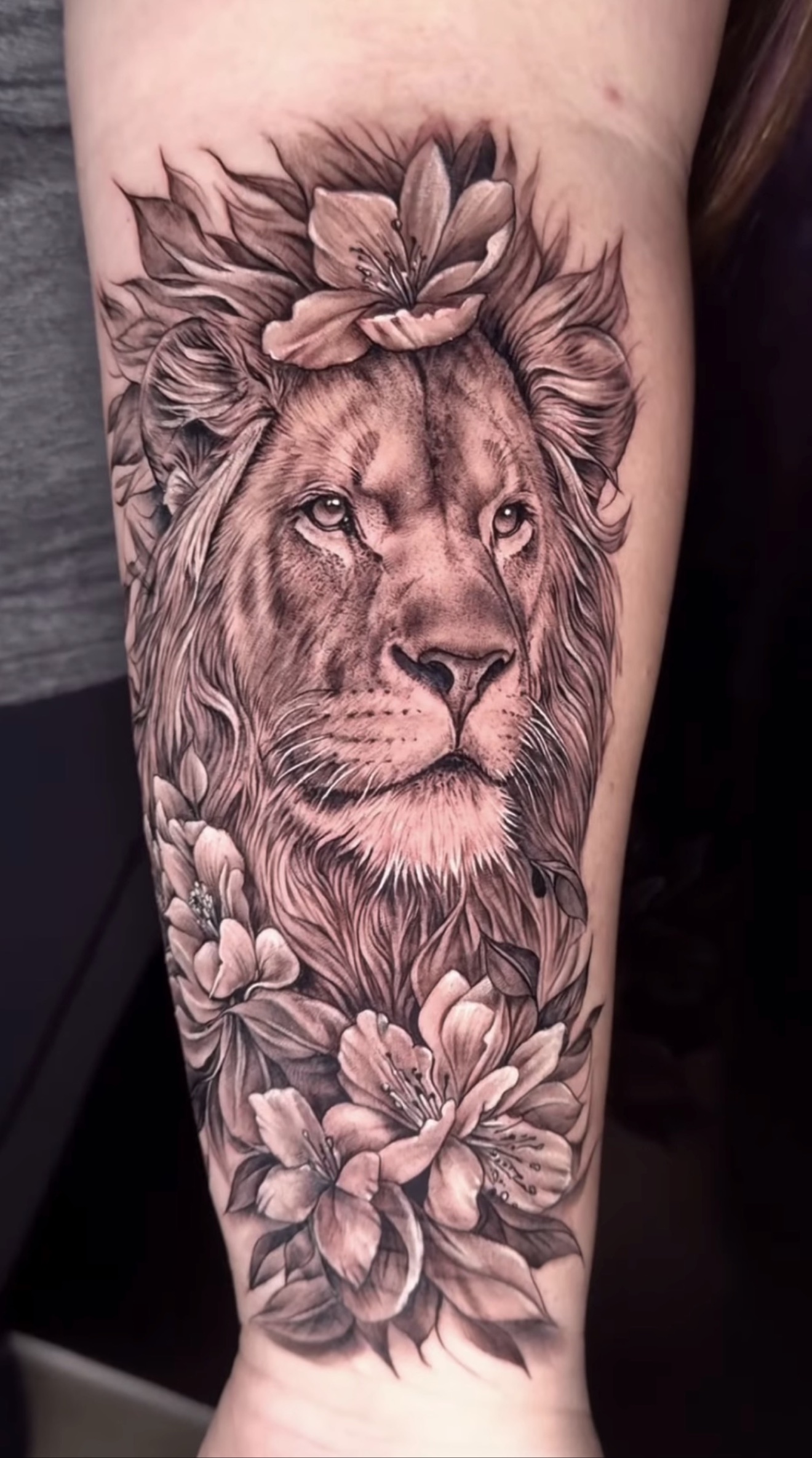 Black and grey lion with flowers tattoo by Reynier Vazquez